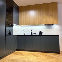 an empty kitchen with wooden floors and cabinets