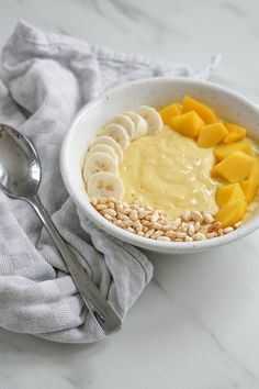 a bowl filled with oatmeal and sliced fruit on top of a table