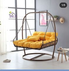 a swing chair with yellow cushions in a living room