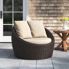 a brown wicker chair sitting on top of a patio