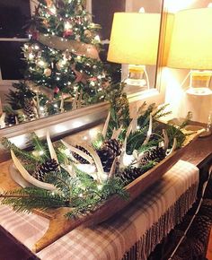 a christmas tree in a wooden sleigh with pine cones and lights on it