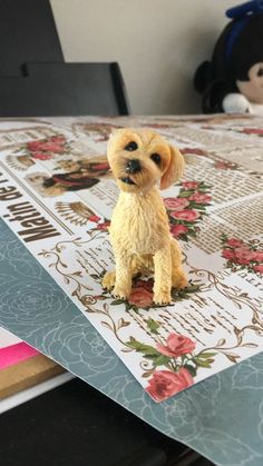 a small toy dog sitting on top of a piece of paper