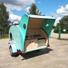 an old camper trailer with its door open and storage compartment opened on the side