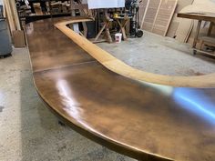 a wooden bench in a shop with lots of work on it