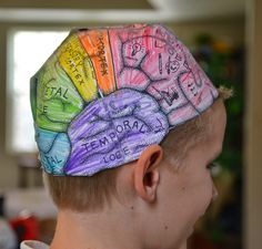 a young boy wearing a colorful hat with words written on it's top and sides