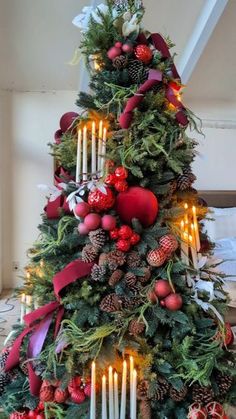 a christmas tree decorated with candles and ornaments