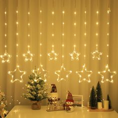 christmas lights hanging from the ceiling in front of a table with presents and decorations on it