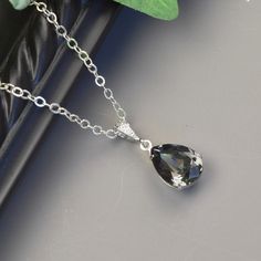 "Charcoal gray necklace featuring a gray swarovski crystal teardrop in a sterling silver plated prong setting attached to a cubic zirconia rhodium bail on a sterling silver chain. The pendant necklace is a deep rich shade of charcoal gray. The perfect necklace for a special occasion and beautiful enough for your bridesmaid jewelry. The pendant is 1 1/4\" long. The chain is sterling silver with a lobster claw clasp and 1 1/2\" extender chain. Multiples available. Message me for pricing. * swarovs Elegant Gray Pendant Jewelry, Silver Teardrop Pendant Necklace For Bridesmaid Gift, Silver Crystal Teardrop Pendant Necklace, Elegant Gray Necklace For Wedding, Grey Necklace Jewelry, Jewelry For Bridesmaids, Grey Necklace, Grey Jewelry, Gray Necklace