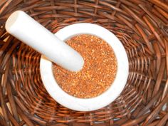 a white mortar in a bowl filled with ground spices