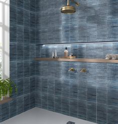 a bathroom with blue tile and gold fixtures