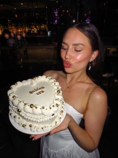 a woman holding a cake with pearls on it