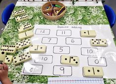 a child is playing with dominos on the table in front of them and other toys