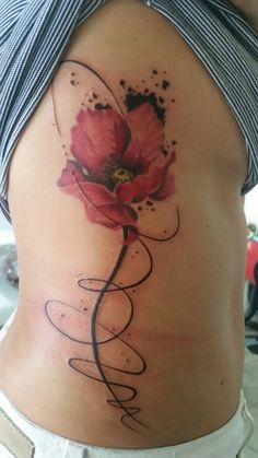 a woman's stomach with a flower tattoo on it