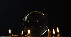 several candles are lit in front of a crystal ball