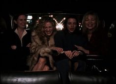 three women sitting in the back of a car with their hands on each other's lap