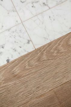 a cell phone sitting on top of a wooden table next to a white tile floor