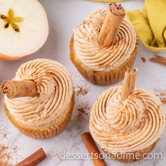 cinnamon apple cupcakes with cinnamon butter frosting and cinnamon stick sticking out of the top