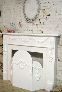 a white fireplace in a room next to a mirror