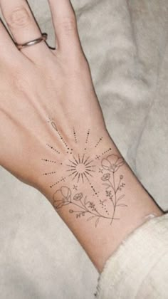 a woman's hand with a flower tattoo on it