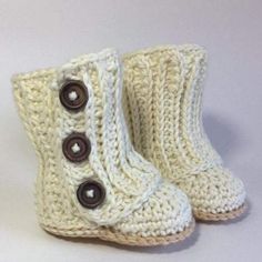 a pair of white crocheted boots with buttons