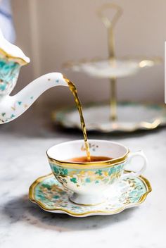 tea being poured into a cup on a saucer