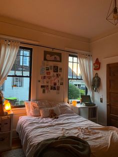 a bed sitting in a bedroom next to a window with curtains on the windowsill