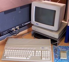 an old computer sitting on top of a wooden desk next to a keyboard and mouse