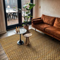 a living room with a couch, coffee table and large glass doors leading to an outside patio