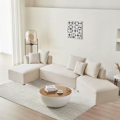 a modern living room with white furniture and wood flooring on the hardwood floors, including a large sectional sofa