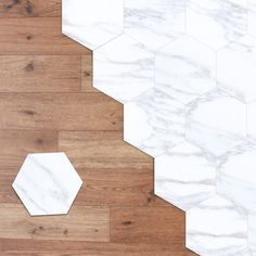 the floor is made up of white marble hexagons and wooden planks