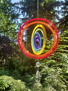 a colorful wind chime hanging in the woods