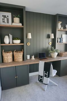 a home office with green painted walls and shelves