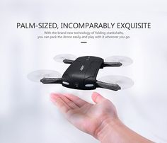 a hand holding a small black and white remote controlled flying device