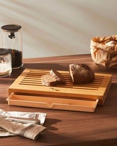 some bread is sitting on a cutting board next to a bagel and salt shaker