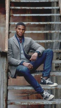 a man sitting on top of a set of stairs next to a metal hand rail