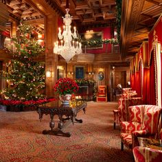 a christmas tree is in the middle of a room with red and gold decorations on the walls