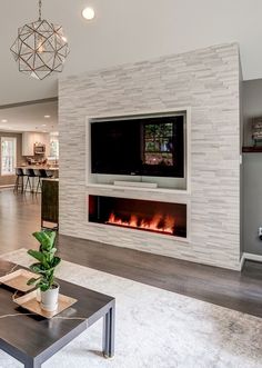 a living room with a fireplace and tv mounted on the wall