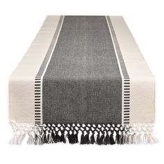 a black and white table runner with tassels