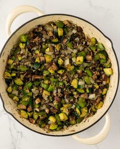 cooked brussel sprouts and mushrooms in a pot on a marble countertop