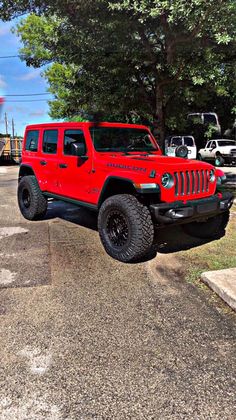 a red jeep is parked in a parking lot