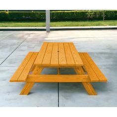 a wooden picnic table sitting on top of a cement floor