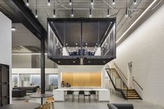 the interior of a modern office building with stairs leading up to an open floor plan