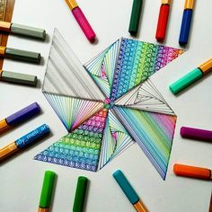 some crayons and markers are laying on the table next to an origami star