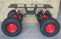 two red wheels are attached to the side of a building with a black frame and metal bar