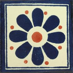 a blue and white tile with an orange dot on it's center, in the shape of a flower