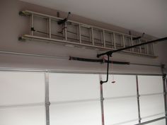 an overhead garage door is shown with wires attached to the ceiling and windows above it