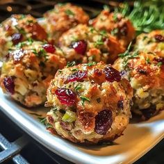 several appetizers on a white plate with green garnish and cranberries