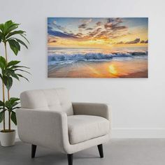 a chair sitting next to a potted plant in front of a painting on the wall