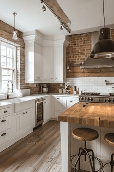 a kitchen with white cabinets and wooden counter tops, two stools in front of the island