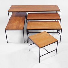 a set of four tables with wooden tops and metal legs